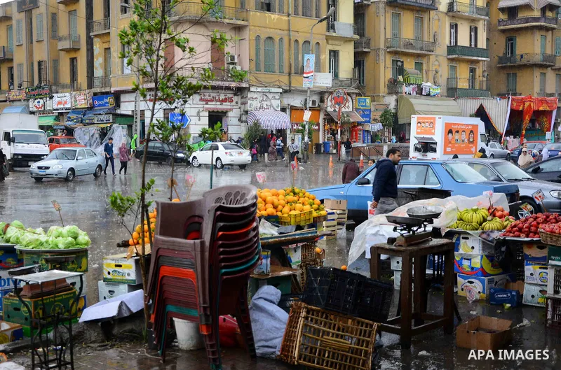 Egyptians walk at street during rain and a cold spell over around country and the capital of Cairo, Egypt December 1, 2016. Photo by Amr Sayed
