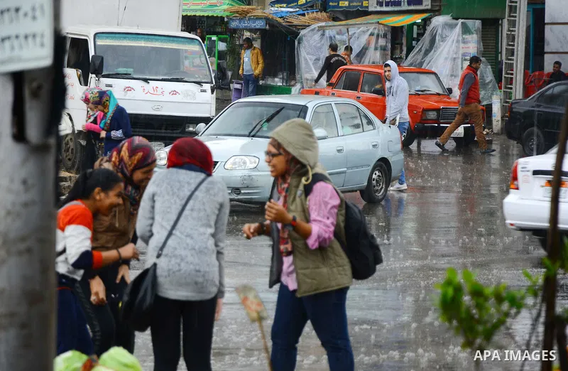 Egyptians walk at street during rain and a cold spell over around country and the capital of Cairo, Egypt December 1, 2016. Photo by Amr Sayed
