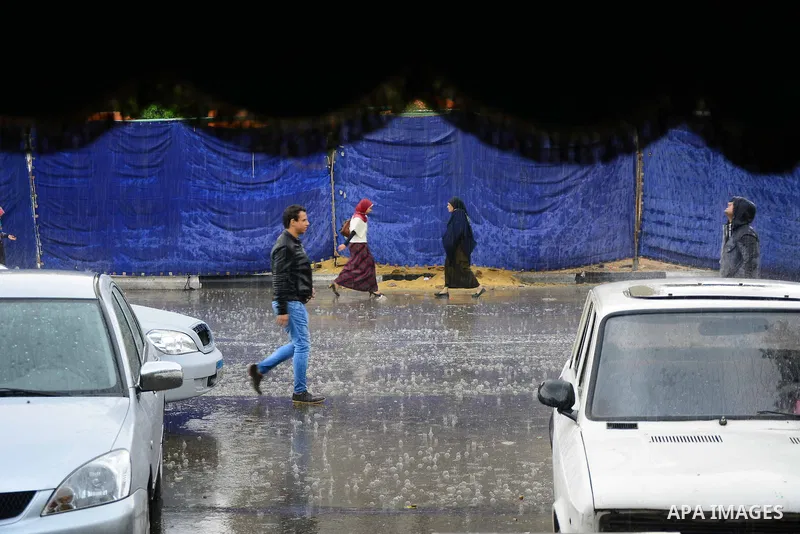 Egyptians walk at street during rain and a cold spell over around country and the capital of Cairo, Egypt December 1, 2016. Photo by Amr Sayed
