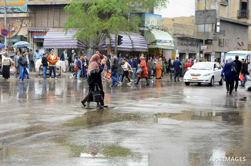 Egyptians walk at street during rain and a cold spell over around country and the capital of Cairo, Egypt December 1, 2016. Photo by Amr Sayed