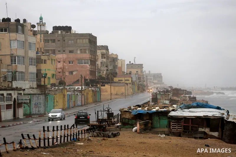 A picture taken on December 1, 2016 shows cars at a street during rain and a cold spell at the al-Shati refugee camp in Gaza City on December 1, 2016. Photo by Mohammed Asad