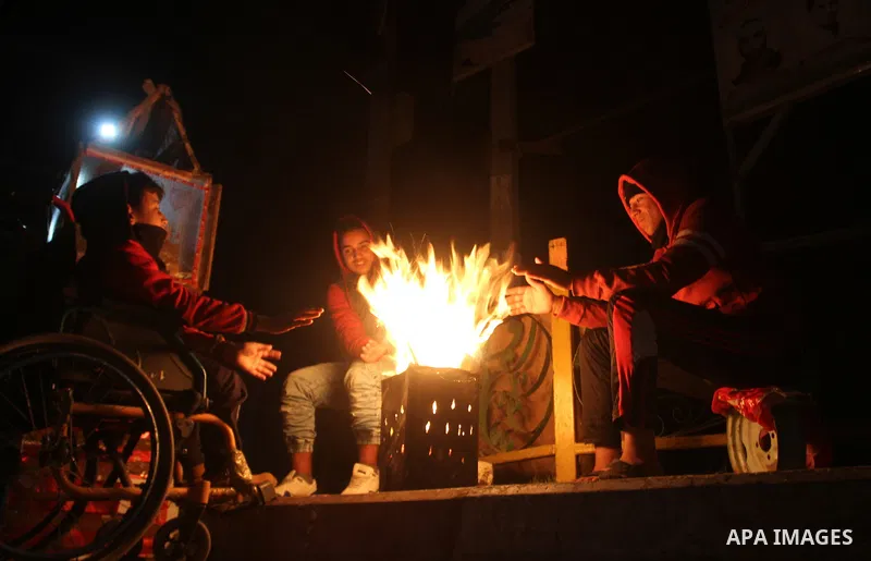 Palestinians warm themselves around a fire during the winter storm, in Rafah in the southern Gaza strip, on December 1, 2016. Photo by Abed Rahim Khatib