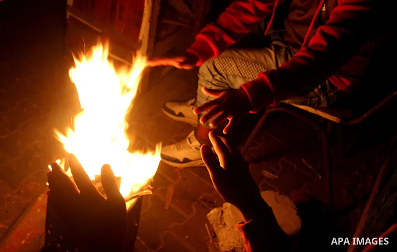 Palestinians warm themselves around a fire during the winter storm, in Rafah in the southern Gaza strip, on December 1, 2016. Photo by Abed Rahim Khatib