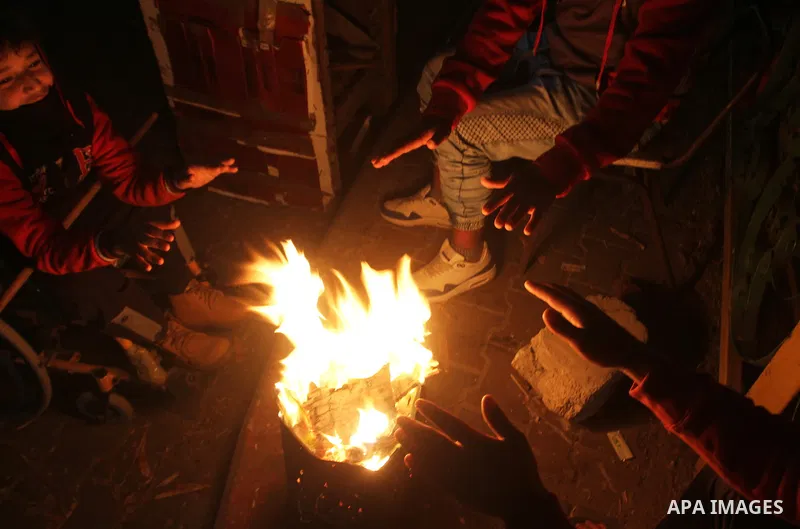 Palestinians warm themselves around a fire during the winter storm, in Rafah in the southern Gaza strip, on December 1, 2016. Photo by Abed Rahim Khatib
