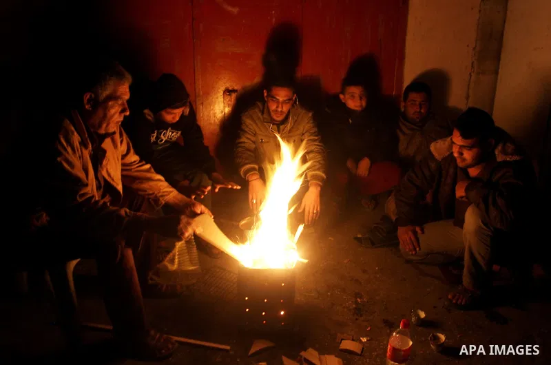 Palestinians warm themselves around a fire during the winter storm, in Rafah in the southern Gaza strip, on December 1, 2016. Photo by Abed Rahim Khatib