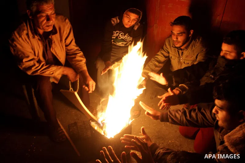 Palestinians warm themselves around a fire during the winter storm, in Rafah in the southern Gaza strip, on December 1, 2016. Photo by Abed Rahim Khatib