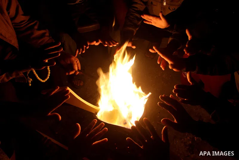 Palestinians warm themselves around a fire during the winter storm, in Rafah in the southern Gaza strip, on December 1, 2016. Photo by Abed Rahim Khatib