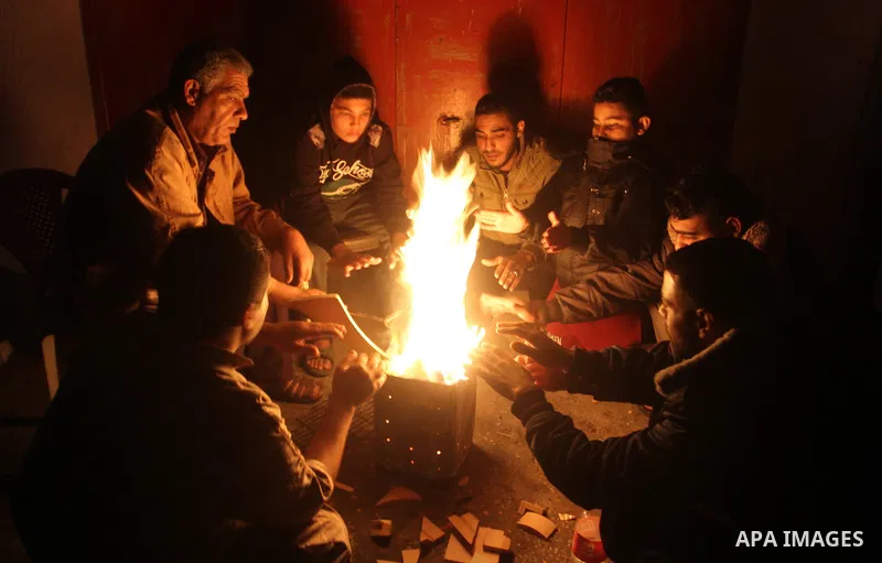 Palestinians warm themselves around a fire during the winter storm, in Rafah in the southern Gaza strip, on December 1, 2016. Photo by Abed Rahim Khatib