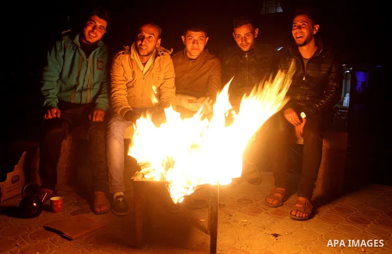 Palestinians warm themselves around a fire during the winter storm, in Rafah in the southern Gaza strip, on December 1, 2016. Photo by Abed Rahim Khatib