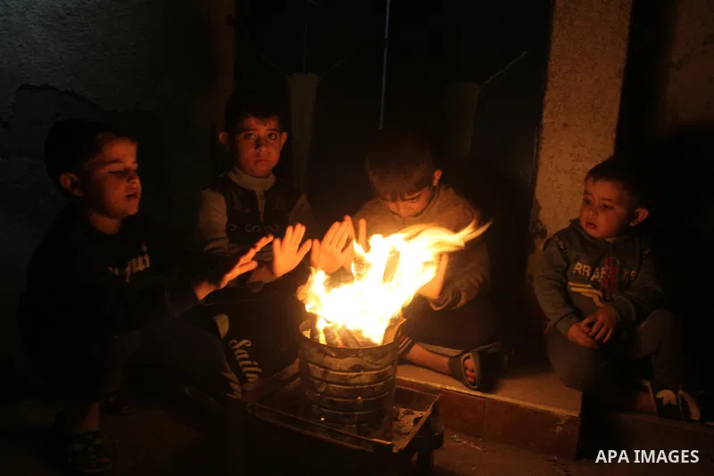 Palestinians warm themselves around a fire during the winter storm, in Rafah in the southern Gaza strip, on December 1, 2016. Photo by Abed Rahim Khatib
