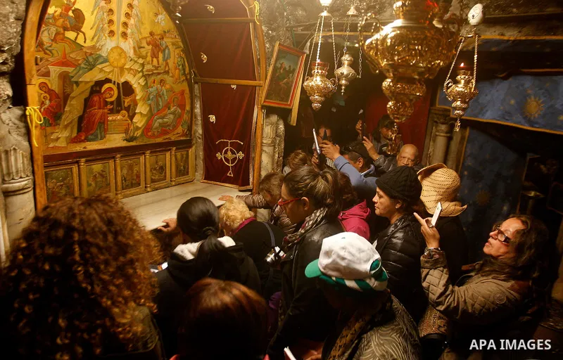 Visitors visit the holy star where Jesus Christ is believed to have been born inside the holy cave in the Church of Nativity during a Christmas tree lighting ceremony in the West Bank town of Bethlehem December 3, 2016....