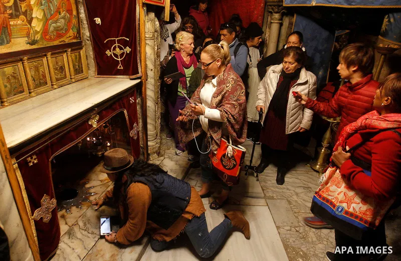 Visitors visit the holy star where Jesus Christ is believed to have been born inside the holy cave in the Church of Nativity during a Christmas tree lighting ceremony in the West Bank town of Bethlehem December 3, 2016....