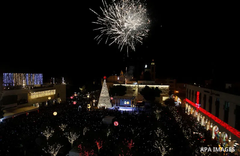 Palestinian Christians watch fireworks marking the lighting of a Christmas tree on December 3, 2016 at the Manger Square near the Church of the Nativity, revered as the site of Jesus Christ's birth, in the biblical West...