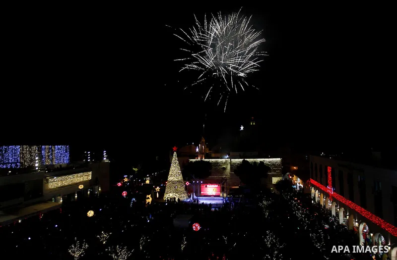 Palestinian Christians watch fireworks marking the lighting of a Christmas tree on December 3, 2016 at the Manger Square near the Church of the Nativity, revered as the site of Jesus Christ's birth, in the biblical West...