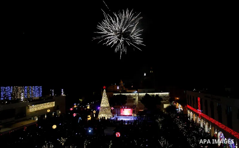 Palestinian Christians watch fireworks marking the lighting of a Christmas tree on December 3, 2016 at the Manger Square near the Church of the Nativity, revered as the site of Jesus Christ's birth, in the biblical West...
