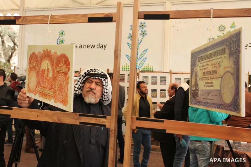 Palestinians attend the first exhibition of coins and postage stamps, in Gaza City, on December 4, 2016. Photo by Ashraf Amra