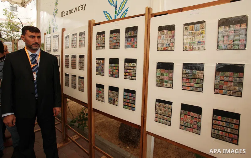 Palestinians attend the first exhibition of coins and postage stamps, in Gaza City, on December 4, 2016. Photo by Ashraf Amra