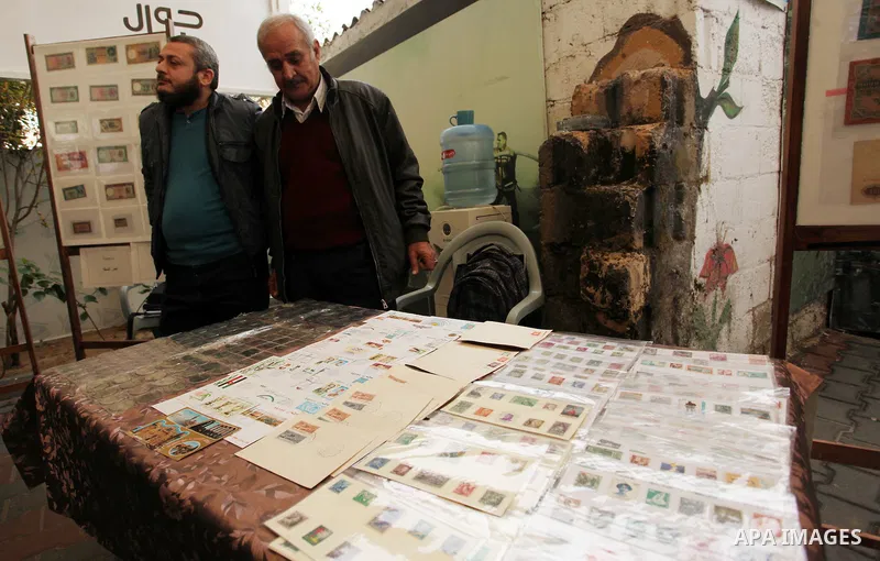 Palestinians attend the first exhibition of coins and postage stamps, in Gaza City, on December 4, 2016. Photo by Ashraf Amra