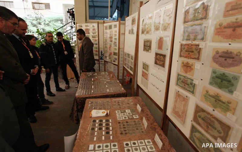 Palestinians attend the first exhibition of coins and postage stamps, in Gaza City, on December 4, 2016. Photo by Ashraf Amra