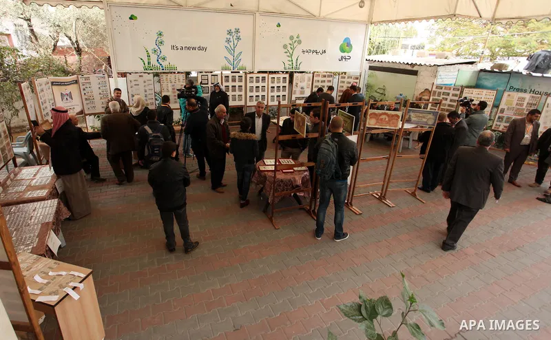 Palestinians attend the first exhibition of coins and postage stamps, in Gaza City, on December 4, 2016. Photo by Ashraf Amra