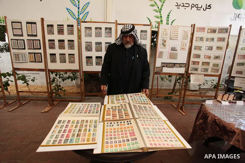Palestinians attend the first exhibition of coins and postage stamps, in Gaza City, on December 4, 2016. Photo by Ashraf Amra