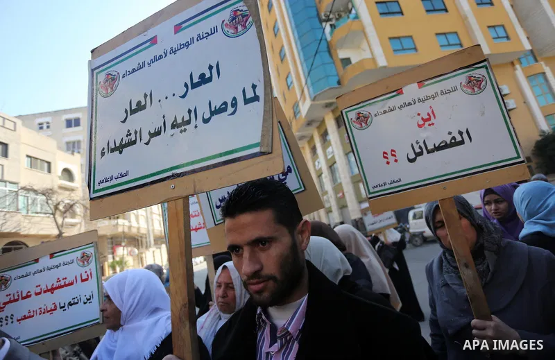 Palestinian families of martyrs take part a protest to demand their rights and salaries, in front of Red cross office in Gaza city, on December 5, 2016. Photo by Mohammed Asad