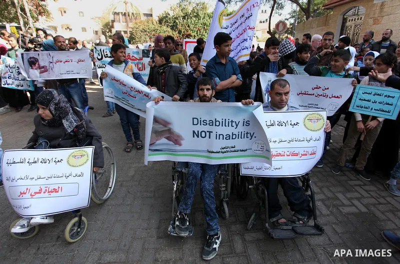 Palestinian girls with disabilities hold banners as they take parts in a rally in Gaza City demanding for the rights of people with disabilities in Gaza on December 5, 2016 Tens of thousands of Gazans are learning to liv...