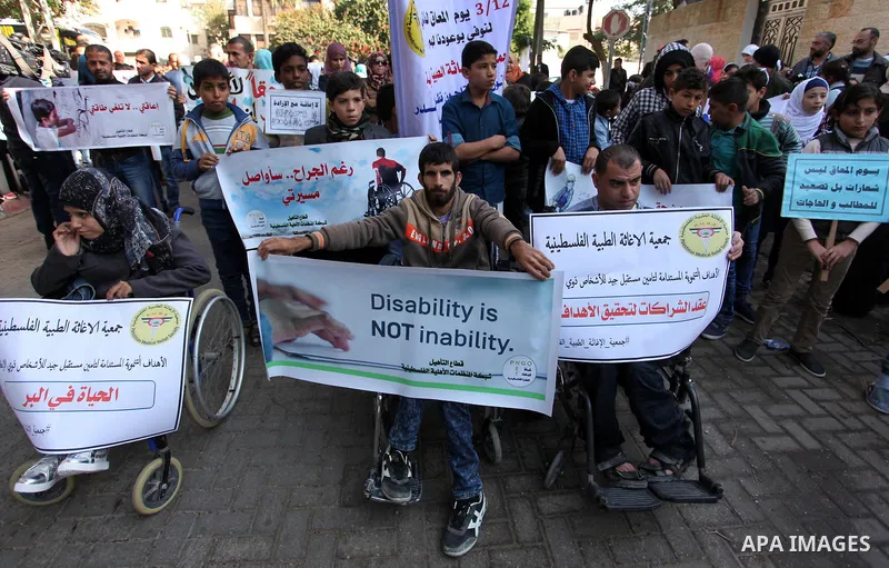 Palestinian girls with disabilities hold banners as they take parts in a rally in Gaza City demanding for the rights of people with disabilities in Gaza on December 5, 2016 Tens of thousands of Gazans are learning to liv...