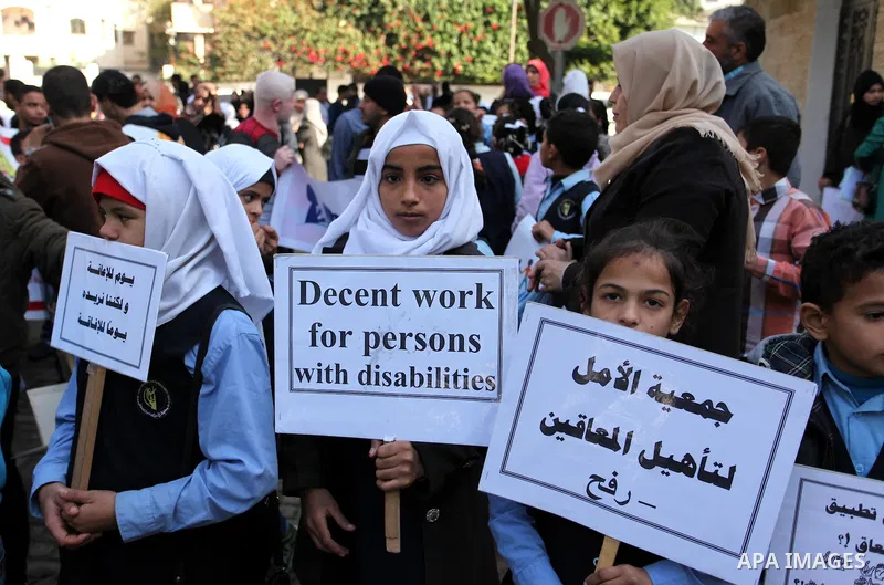Palestinian girls with disabilities hold banners as they take parts in a rally in Gaza City demanding for the rights of people with disabilities in Gaza on December 5, 2016 Tens of thousands of Gazans are learning to liv...