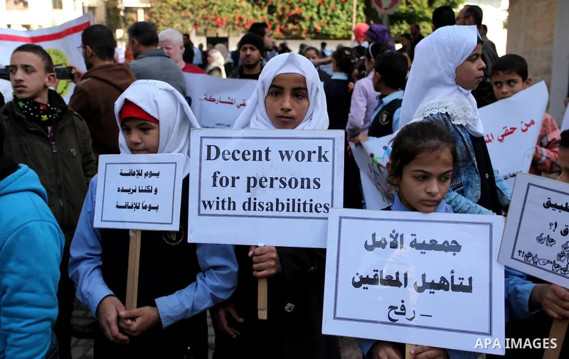 Palestinian girls with disabilities hold banners as they take parts in a rally in Gaza City demanding for the rights of people with disabilities in Gaza on December 5, 2016 Tens of thousands of Gazans are learning to liv...