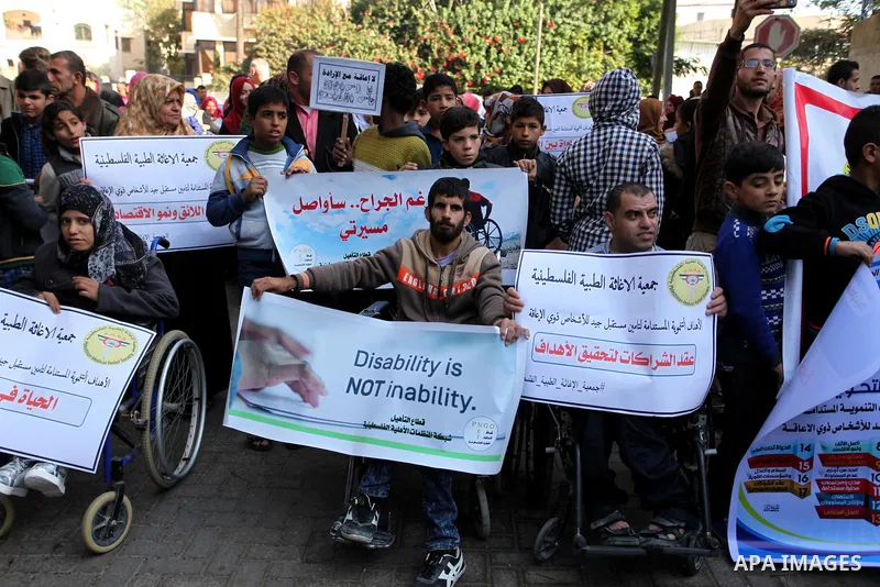 Palestinian girls with disabilities hold banners as they take parts in a rally in Gaza City demanding for the rights of people with disabilities in Gaza on December 5, 2016 Tens of thousands of Gazans are learning to liv...