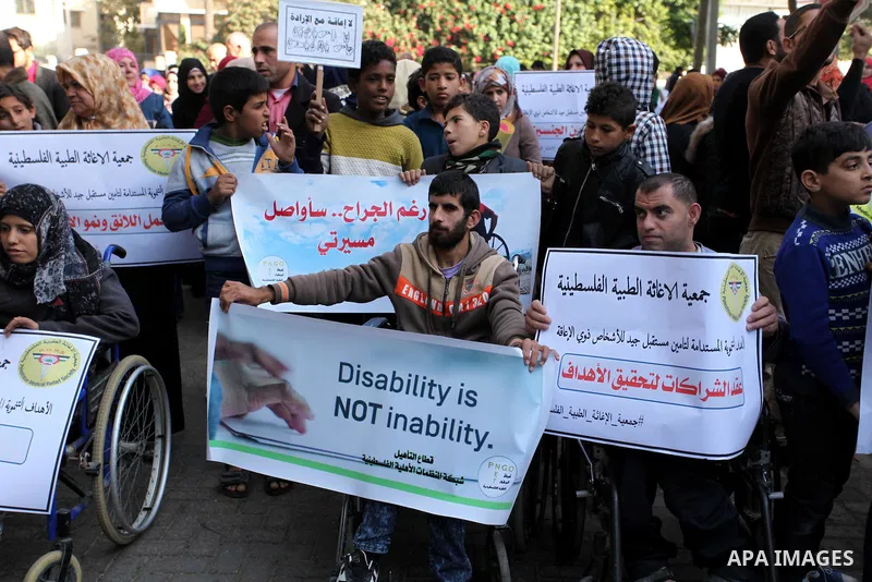 Palestinian girls with disabilities hold banners as they take parts in a rally in Gaza City demanding for the rights of people with disabilities in Gaza on December 5, 2016 Tens of thousands of Gazans are learning to liv...