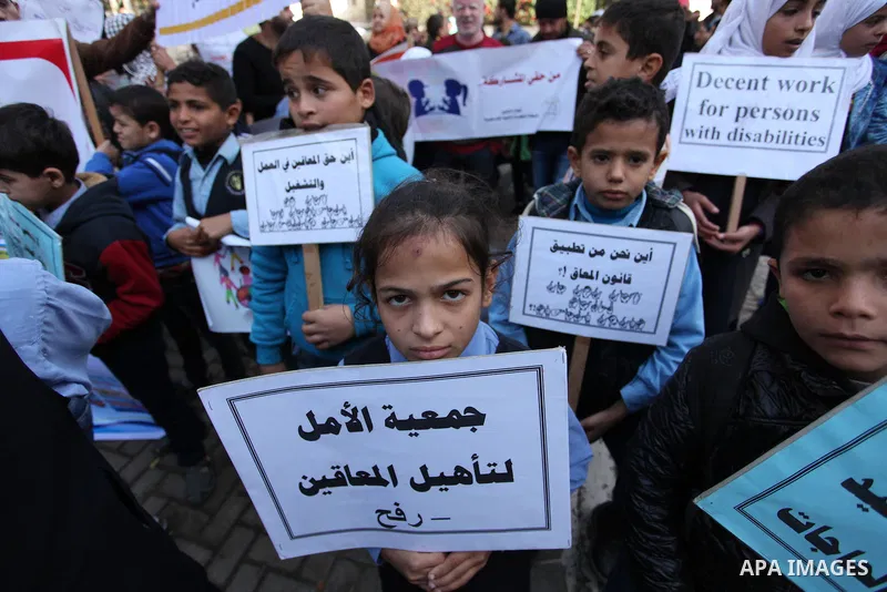 Palestinian girls with disabilities hold banners as they take parts in a rally in Gaza City demanding for the rights of people with disabilities in Gaza on December 5, 2016 Tens of thousands of Gazans are learning to liv...