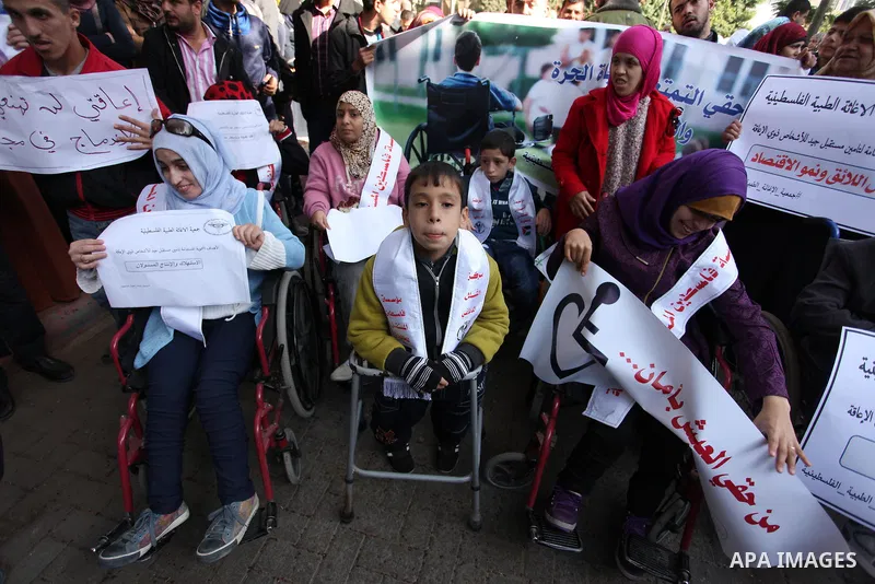 Palestinian girls with disabilities hold banners as they take parts in a rally in Gaza City demanding for the rights of people with disabilities in Gaza on December 5, 2016 Tens of thousands of Gazans are learning to liv...