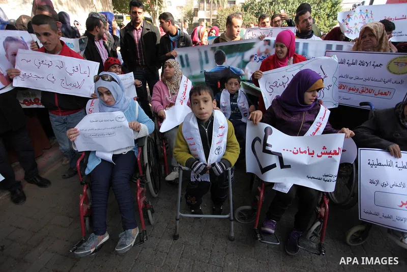 Palestinian girls with disabilities hold banners as they take parts in a rally in Gaza City demanding for the rights of people with disabilities in Gaza on December 5, 2016 Tens of thousands of Gazans are learning to liv...