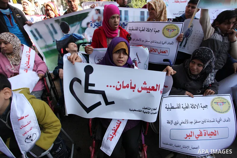 Palestinian girls with disabilities hold banners as they take parts in a rally in Gaza City demanding for the rights of people with disabilities in Gaza on December 5, 2016 Tens of thousands of Gazans are learning to liv...