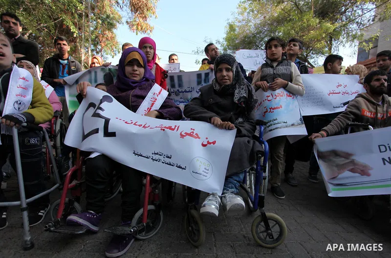 Palestinian girls with disabilities hold banners as they take parts in a rally in Gaza City demanding for the rights of people with disabilities in Gaza on December 5, 2016 Tens of thousands of Gazans are learning to liv...