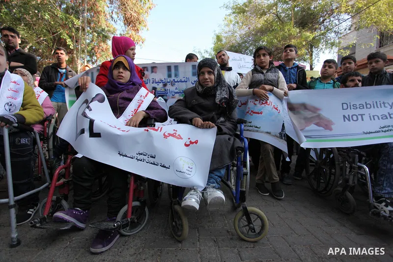 Palestinian girls with disabilities hold banners as they take parts in a rally in Gaza City demanding for the rights of people with disabilities in Gaza on December 5, 2016 Tens of thousands of Gazans are learning to liv...