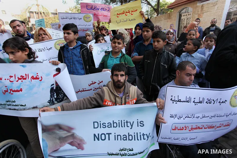 Palestinian girls with disabilities hold banners as they take parts in a rally in Gaza City demanding for the rights of people with disabilities in Gaza on December 5, 2016 Tens of thousands of Gazans are learning to liv...
