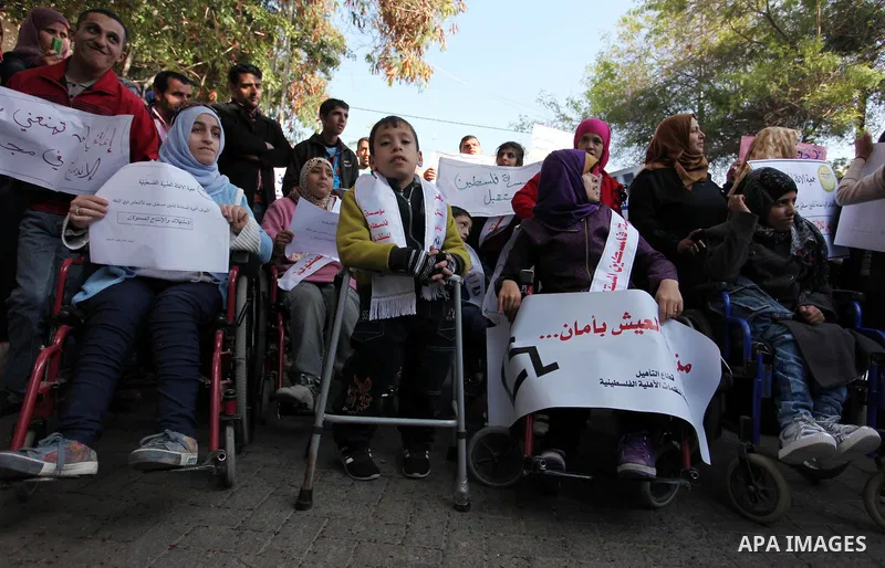 Palestinian girls with disabilities hold banners as they take parts in a rally in Gaza City demanding for the rights of people with disabilities in Gaza on December 5, 2016 Tens of thousands of Gazans are learning to liv...