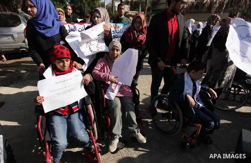 Palestinian girls with disabilities hold banners as they take parts in a rally in Gaza City demanding for the rights of people with disabilities in Gaza on December 5, 2016 Tens of thousands of Gazans are learning to liv...