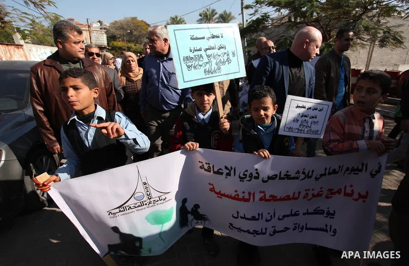Palestinian girls with disabilities hold banners as they take parts in a rally in Gaza City demanding for the rights of people with disabilities in Gaza on December 5, 2016 Tens of thousands of Gazans are learning to liv...