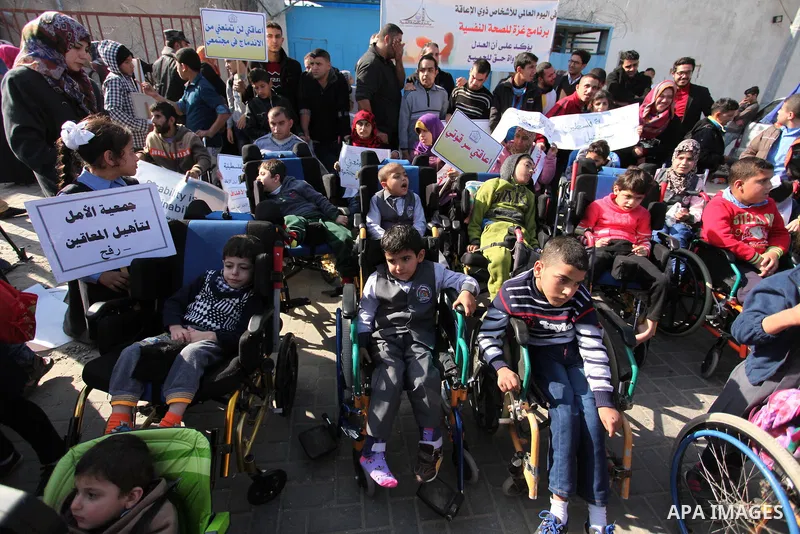 Palestinian girls with disabilities hold banners as they take parts in a rally in Gaza City demanding for the rights of people with disabilities in Gaza on December 5, 2016 Tens of thousands of Gazans are learning to liv...
