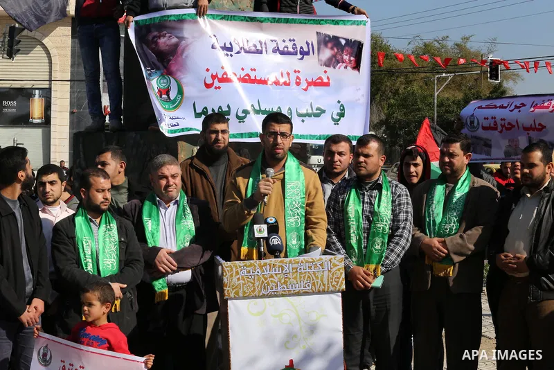 Palestinian youths hold banners and flags during a protest to show solidarity with the people in Burma and Syria, in Gaza city on December 6, 2016. Photo by Mohammed Asad