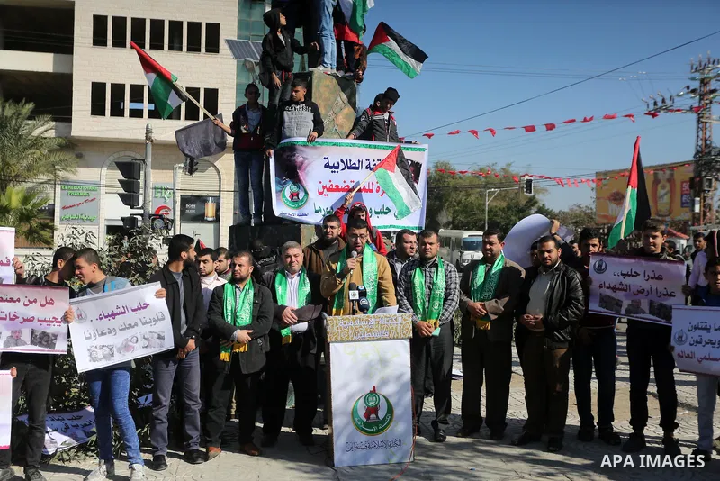 Palestinian youths hold banners and flags during a protest to show solidarity with the people in Burma and Syria, in Gaza city on December 6, 2016. Photo by Mohammed Asad