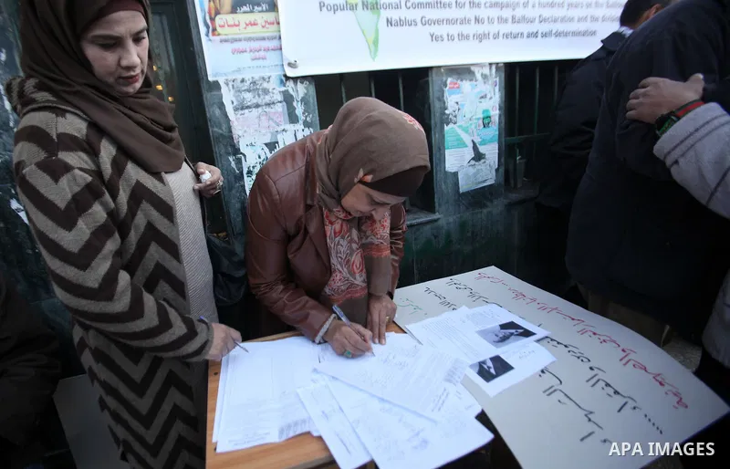 Palestinians hold banners during a campaign of 100 years on the Balfour Declaration, in the West Bank city of Nablus on December 6, 2016. The 1917 Balfour Declaration is a formal statement of policy by the British govern...