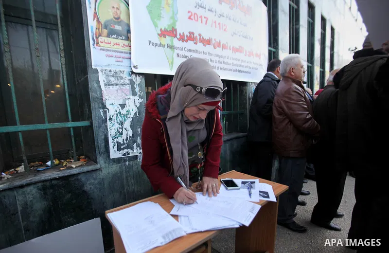 Palestinians hold banners during a campaign of 100 years on the Balfour Declaration, in the West Bank city of Nablus on December 6, 2016. The 1917 Balfour Declaration is a formal statement of policy by the British govern...