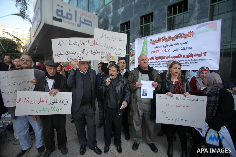 Palestinians hold banners during a campaign of 100 years on the Balfour Declaration, in the West Bank city of Nablus on December 6, 2016. The 1917 Balfour Declaration is a formal statement of policy by the British govern...
