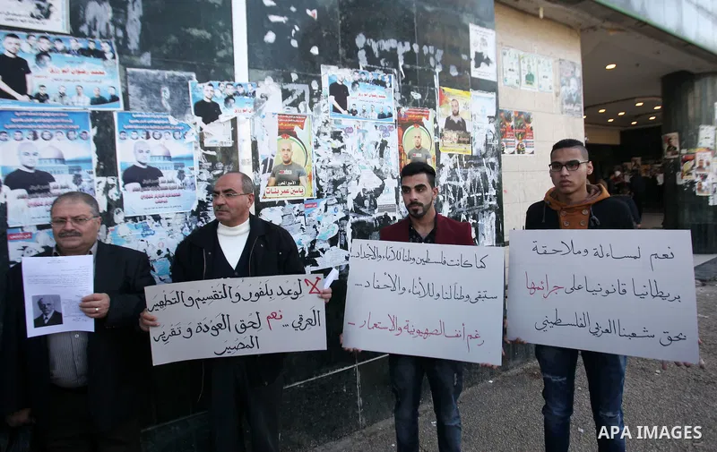 Palestinians hold banners during a campaign of 100 years on the Balfour Declaration, in the West Bank city of Nablus on December 6, 2016. The 1917 Balfour Declaration is a formal statement of policy by the British govern...