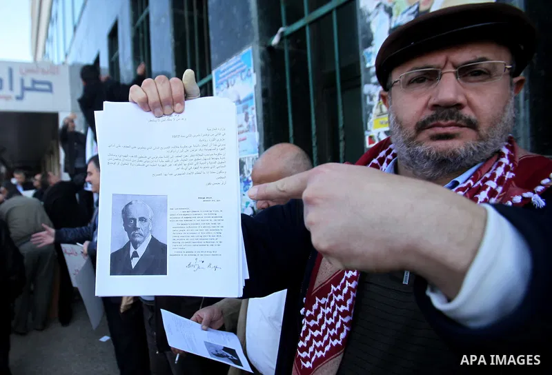 Palestinians hold banners during a campaign of 100 years on the Balfour Declaration, in the West Bank city of Nablus on December 6, 2016. The 1917 Balfour Declaration is a formal statement of policy by the British govern...